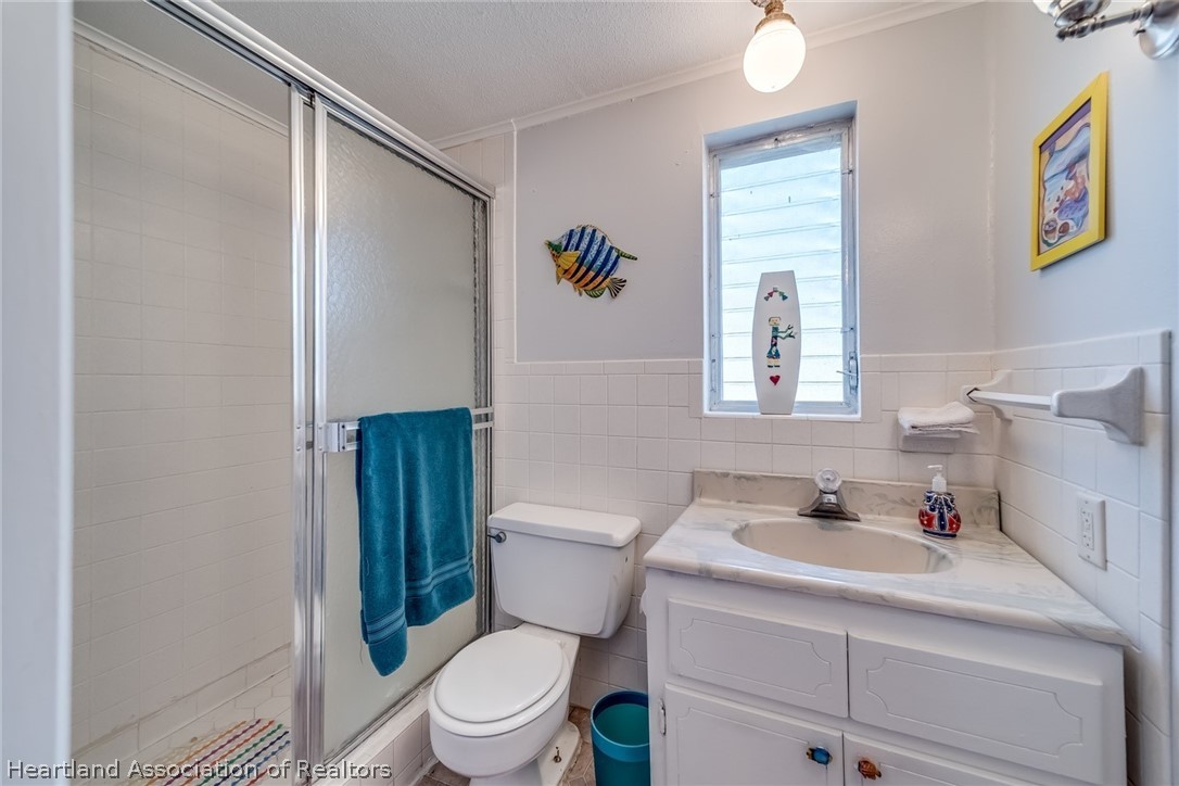 3264 Golfview Road Sebring, FL 33875 - Photo 17 of 27 a bathroom with a sink mirror vanity and toilet