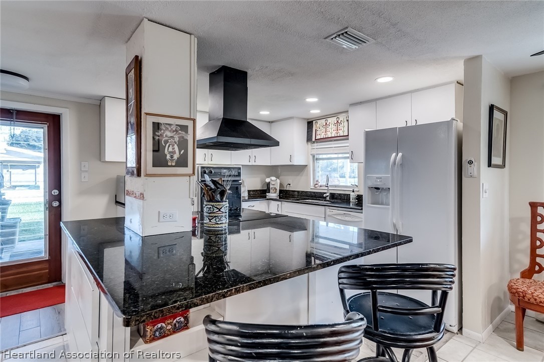 3264 Golfview Road Sebring, FL 33875 - Photo 2 of 27 a kitchen with stainless steel appliances granite countertop a stove a refrigerator and a stove