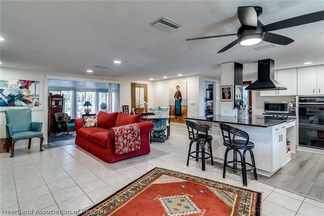 3264 Golfview Road Sebring, FL 33875 - Photo 5 of 27 a living room with stainless steel appliances kitchen island granite countertop furniture and a view of kitchen