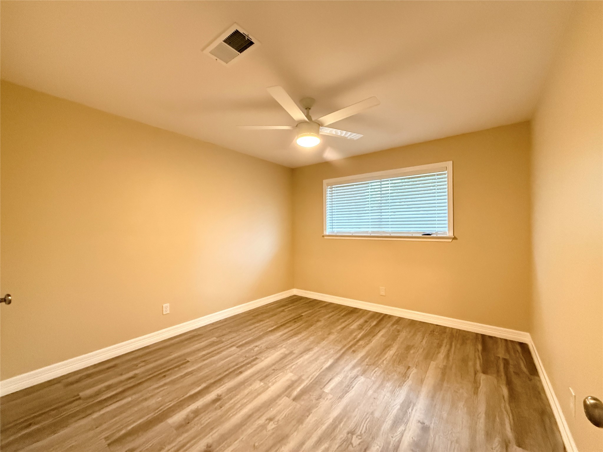 602 Cole Street Webster, TX 77598 - Photo 14 of 18 a view of an empty room with wooden floor and a ceiling fan