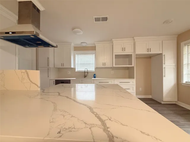 a large kitchen with cabinets and a rug