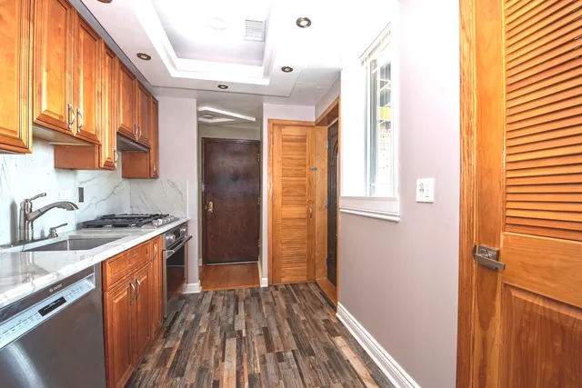 a kitchen with a sink and wooden floor