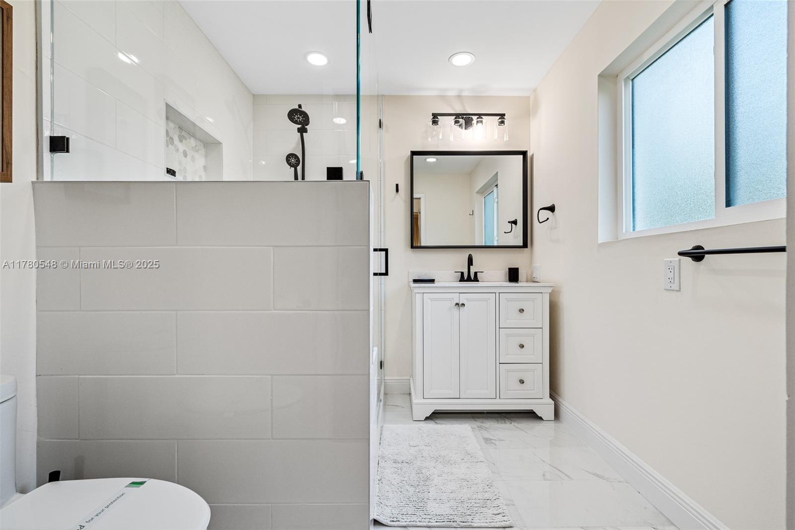 2231 Northeast 38th Street Lighthouse Point, FL 33064 - Photo 14 of 18 a bathroom with a sink a toilet and mirror