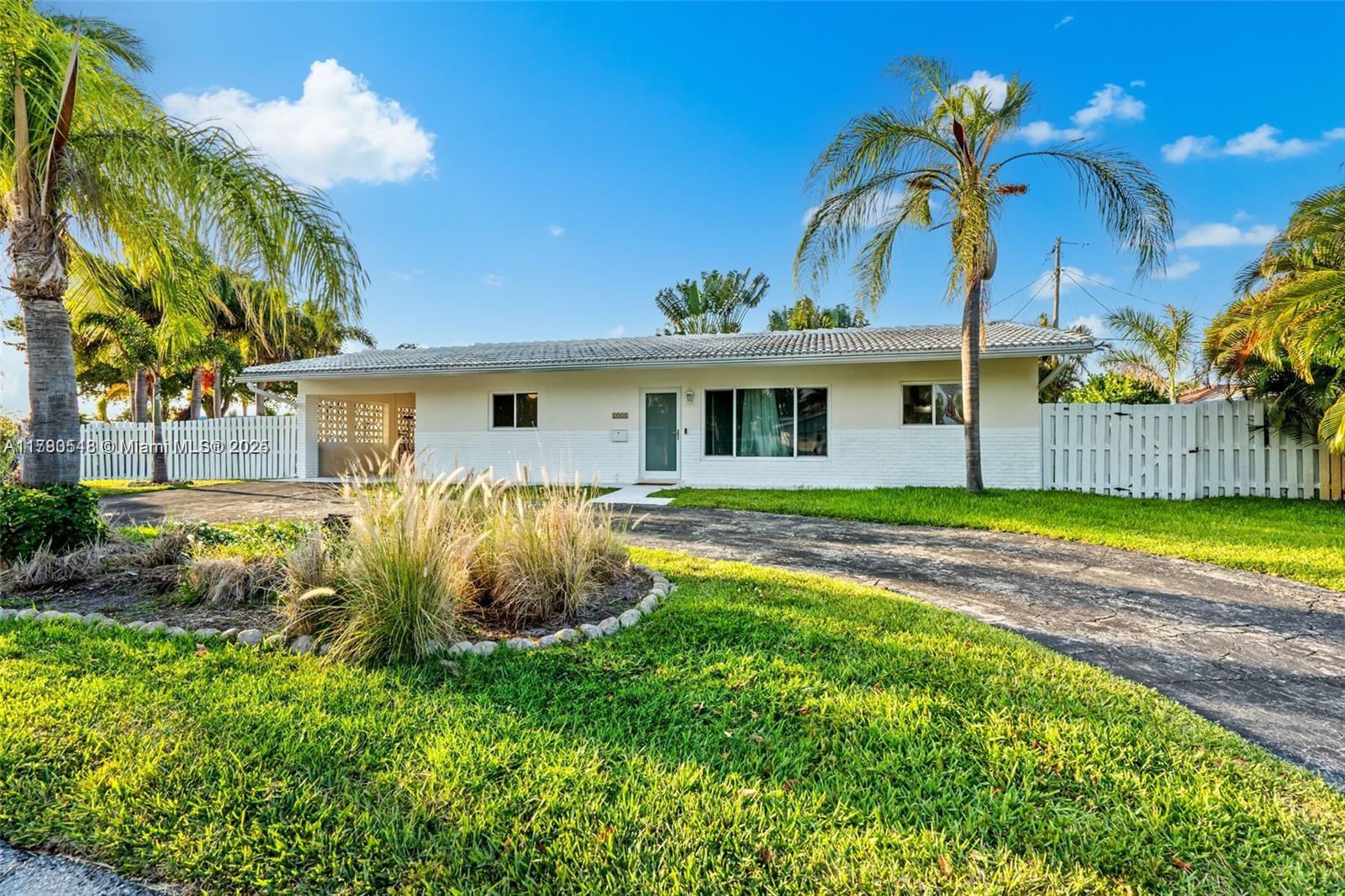 2231 Northeast 38th Street Lighthouse Point, FL 33064 - Photo 2 of 18 a front view of a house with garden