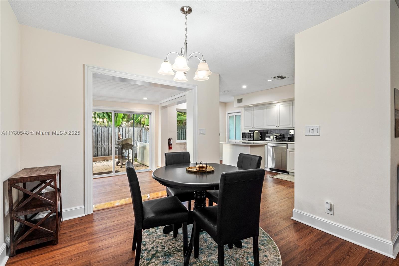 2231 Northeast 38th Street Lighthouse Point, FL 33064 - Photo 3 of 18 a dining room with furniture a chandelier and wooden floor