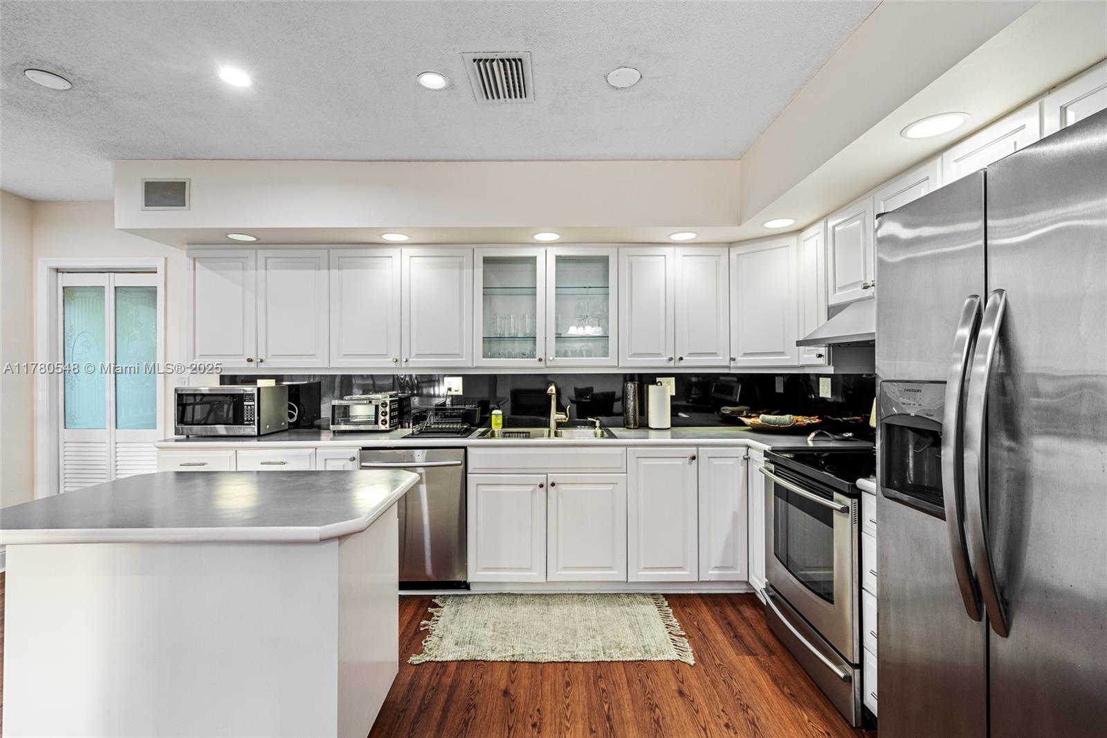 2231 Northeast 38th Street Lighthouse Point, FL 33064 - Photo 4 of 18 a kitchen with stainless steel appliances granite countertop a stove a sink and a refrigerator