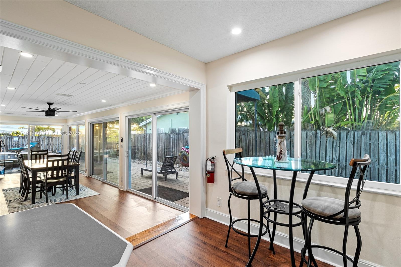 2231 Northeast 38th Street Lighthouse Point, FL 33064 - Photo 5 of 18 a dining room with furniture large windows and wooden floor
