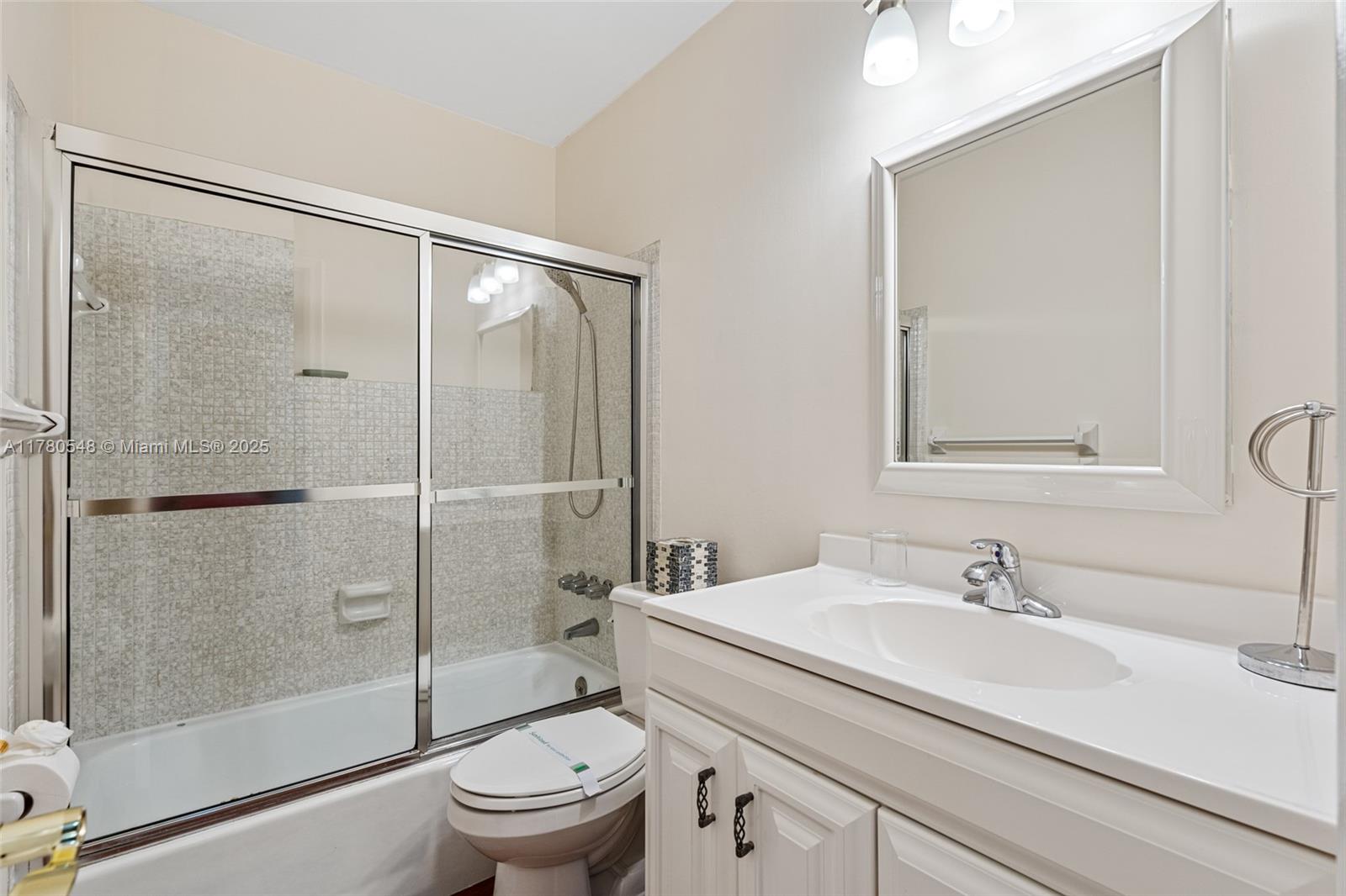2231 Northeast 38th Street Lighthouse Point, FL 33064 - Photo 8 of 18 a bathroom with a shower sink vanity mirror and toilet