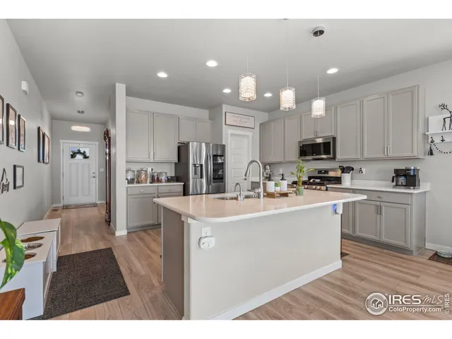 a kitchen with stainless steel appliances kitchen island granite countertop a sink and a refrigerator