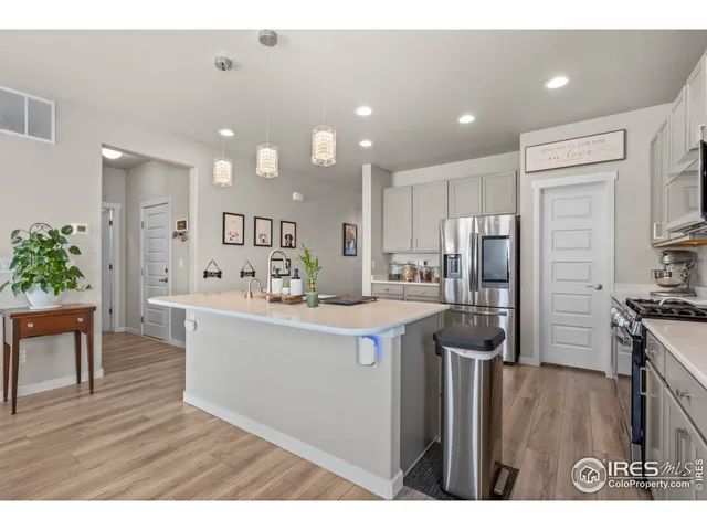 a kitchen with kitchen island a counter top space a sink stainless steel appliances and cabinets