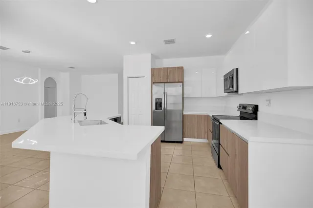 a large white kitchen with cabinets and stainless steel appliances
