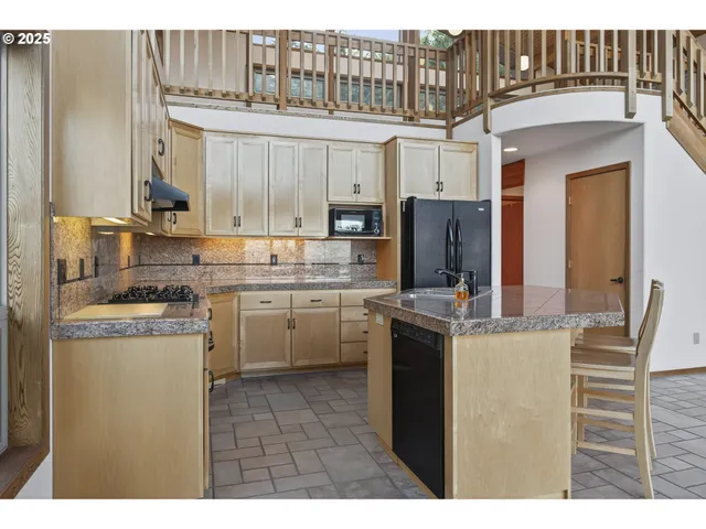a kitchen with kitchen island a counter top space cabinets and a refrigerator