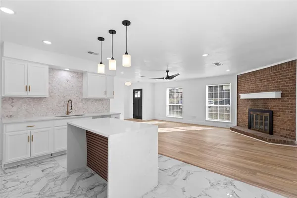 a large kitchen with granite countertop a stove and a sink