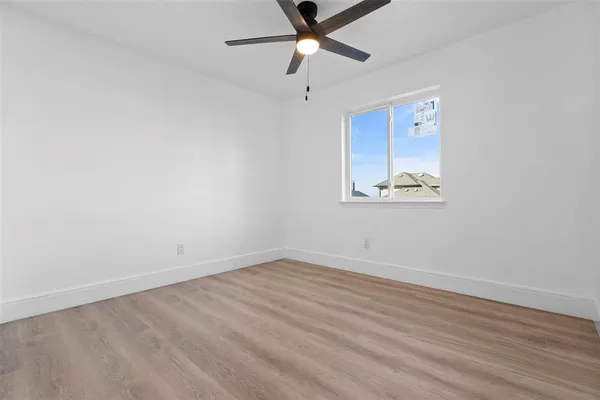 an empty room with a window and a fan