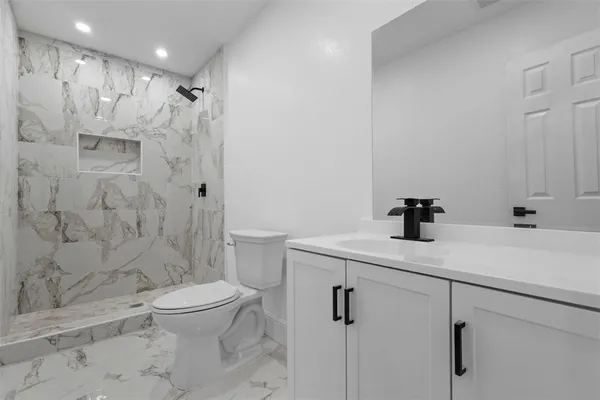 a bathroom with a sink a toilet and shower