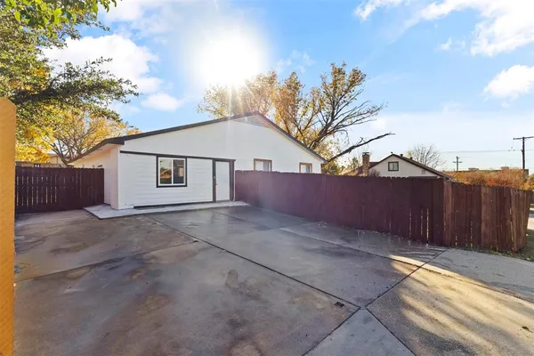 a view of a house with a yard and wooden fence