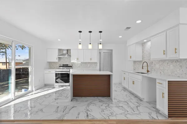 a large kitchen with kitchen island a sink stainless steel appliances and cabinets