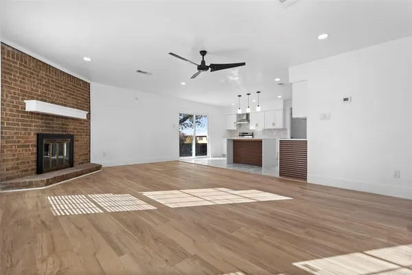 an empty room with kitchen and fireplace
