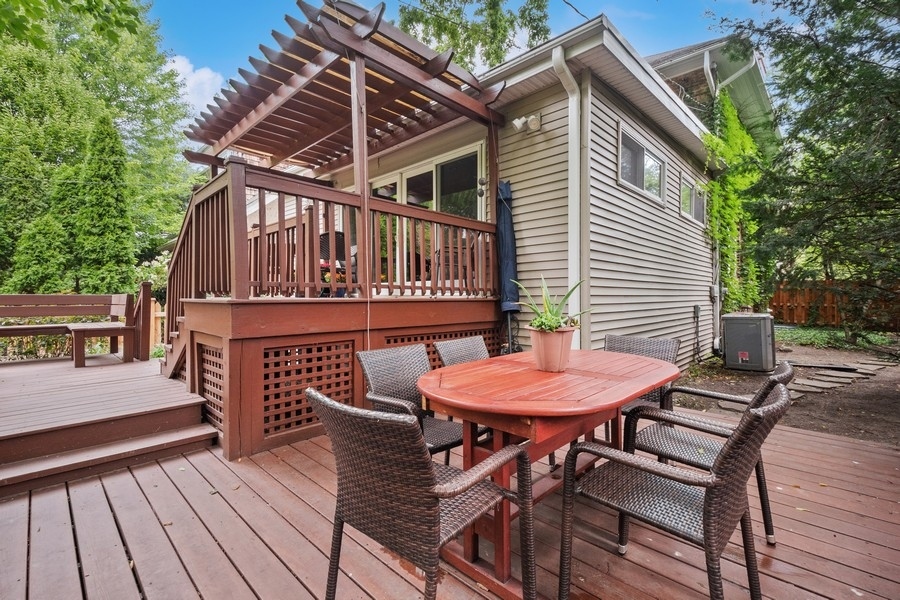 606 Barton Avenue Evanston, IL 60202 - Photo 21 of 27 a view of a roof deck with table and chairs with wooden floor and fence