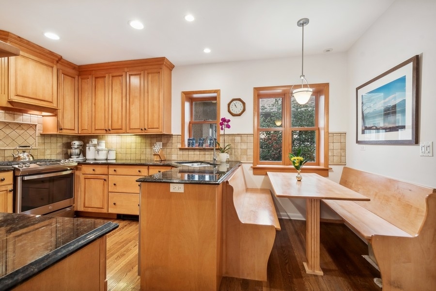 606 Barton Avenue Evanston, IL 60202 - Photo 8 of 27 a kitchen with stainless steel appliances granite countertop a stove top oven a sink a dining table and chairs