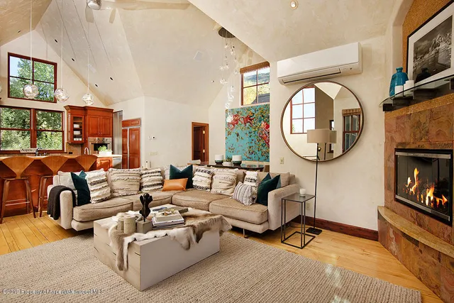 a living room with furniture a mirror a fireplace and a flat screen tv