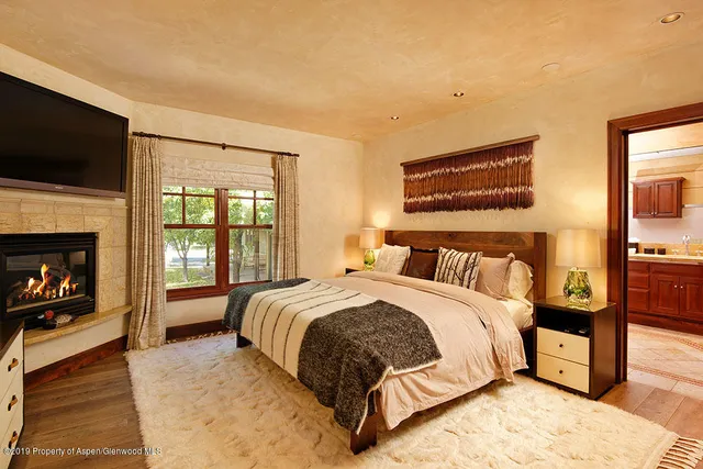 a large bedroom with a bed and a flat screen tv