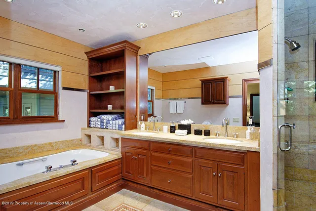 a spacious bathroom with a double vanity sink a mirror and a bathtub