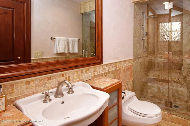 a bathroom with a sink a toilet and shower