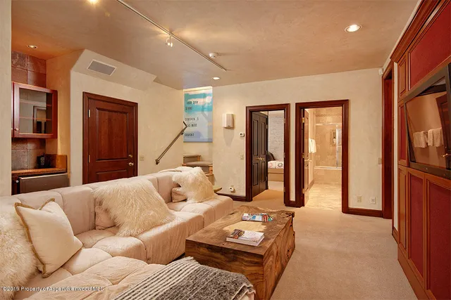 a living room with furniture a large window and a flat screen tv