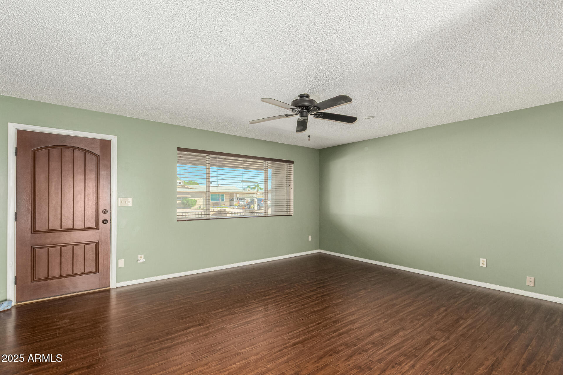 1206 South Grand Drive Apache Junction, AZ 85120 - Photo 5 of 26 a view of empty room with wooden floor and fan