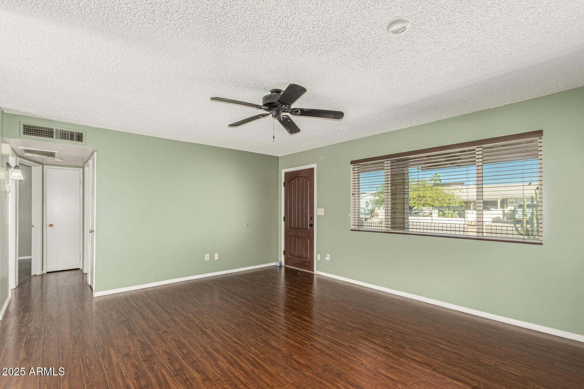 1206 South Grand Drive Apache Junction, AZ 85120 - Photo 6 of 26 a view of an empty room with wooden floor and a window