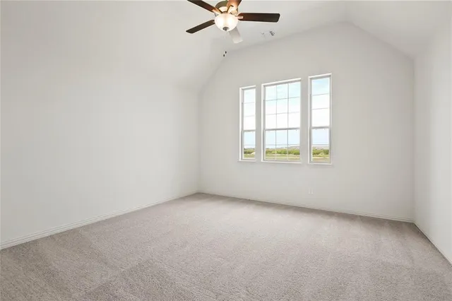 an empty room with a window and a ceiling fan
