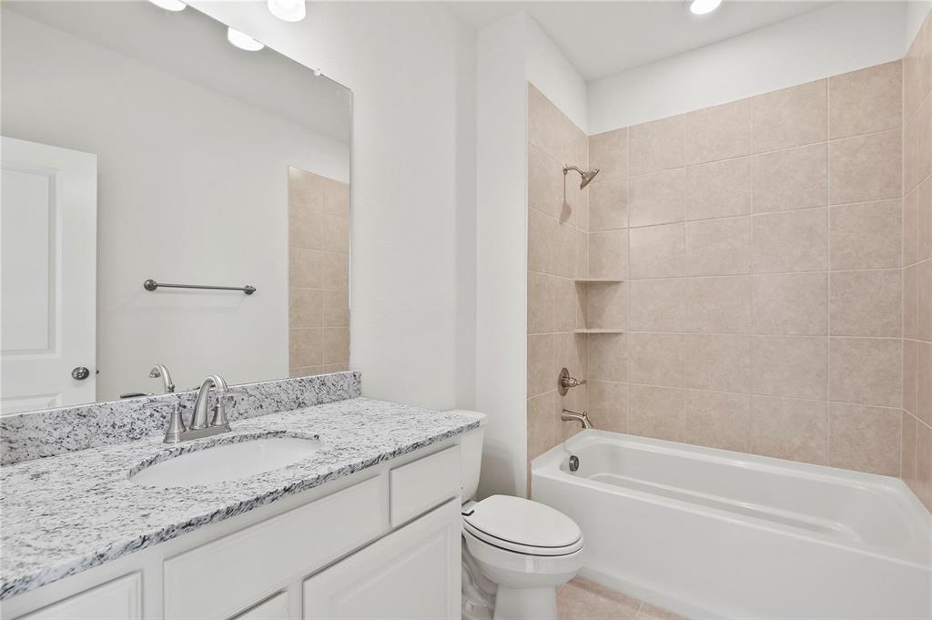 4721 Smokey Quartz Lane Arlington, TX 76005 - Photo 17 of 17 a bathroom with a granite countertop sink toilet and shower