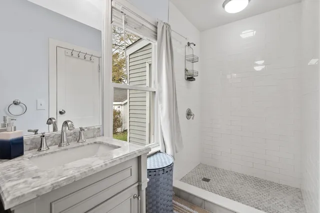 a bathroom with a granite countertop sink a mirror and a shower