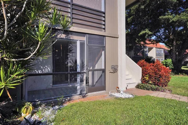 a view of a house with wooden deck and furniture