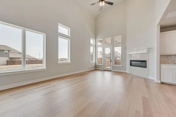 wooden floor fireplace and windows in an empty room