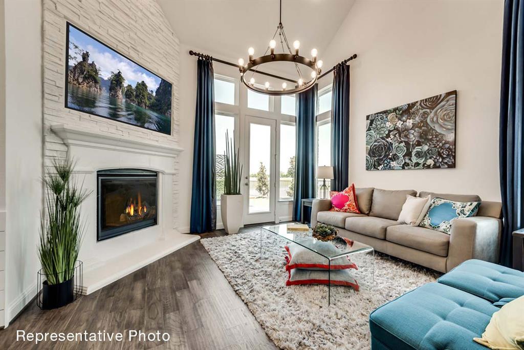 656 Blakelys Way Fate, TX 75189 - Photo 3 of 22 a living room with furniture a fireplace and a flat screen tv