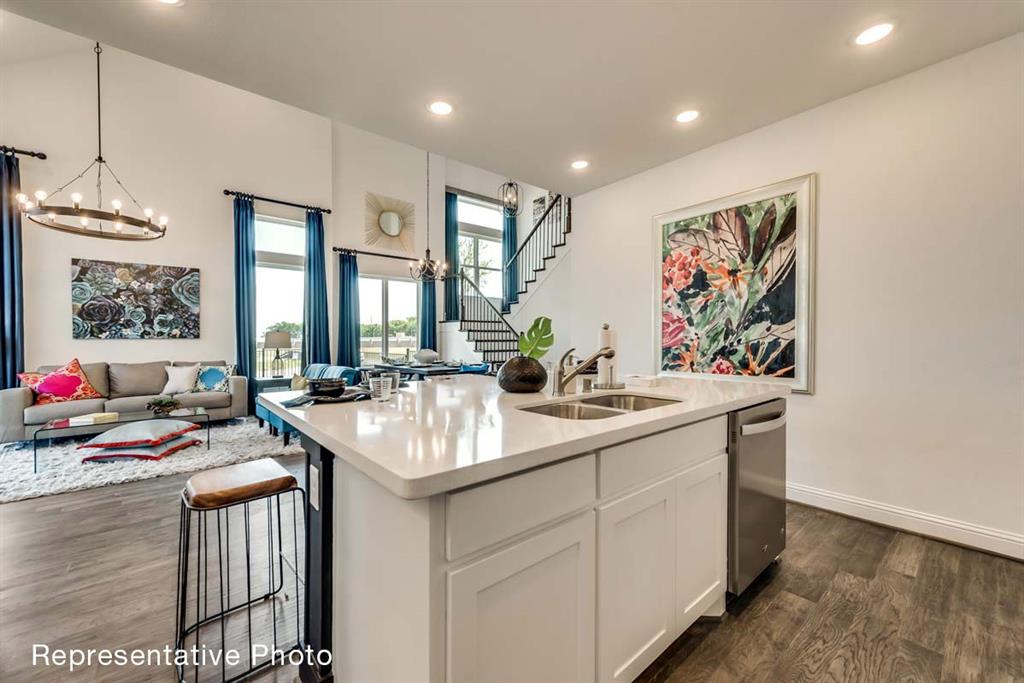 656 Blakelys Way Fate, TX 75189 - Photo 4 of 22 a view of kitchen island a sink and a refrigerator