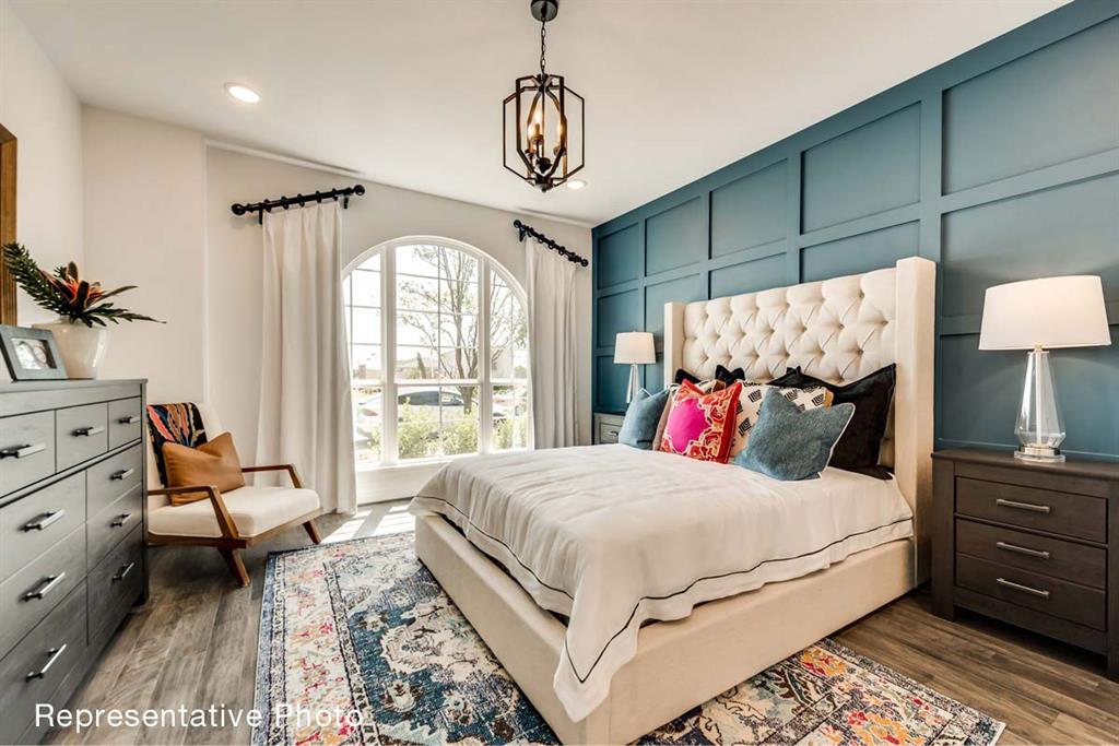 656 Blakelys Way Fate, TX 75189 - Photo 6 of 22 a bedroom with a bed and a chandelier