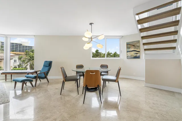 a dining room with furniture a rug and a chandelier