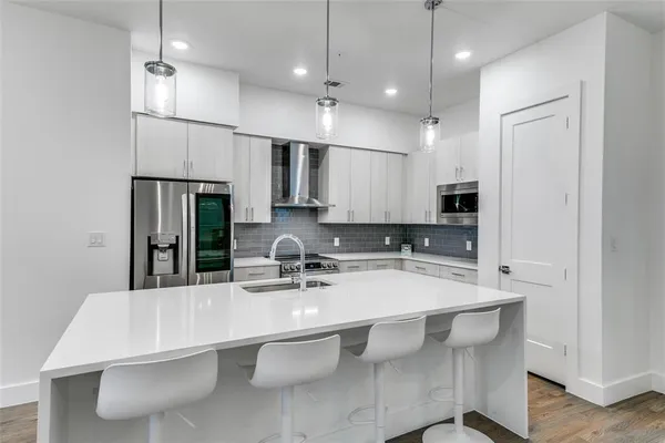 a kitchen with kitchen island a sink stove and refrigerator