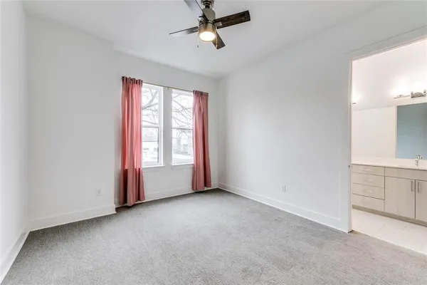 an empty room with windows and cabinet