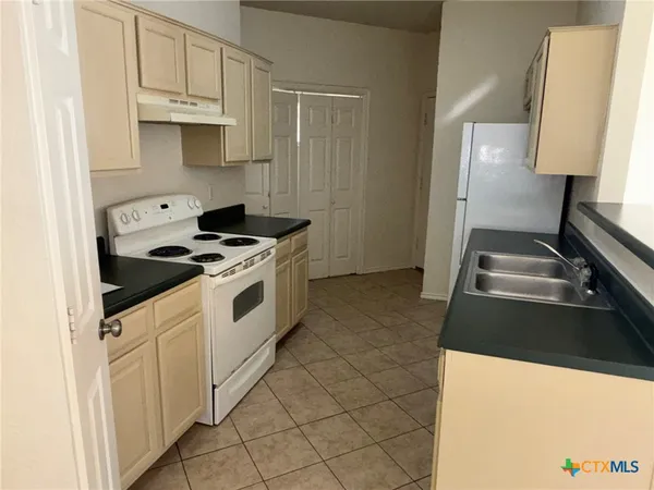 a kitchen with granite countertop a stove and a sink