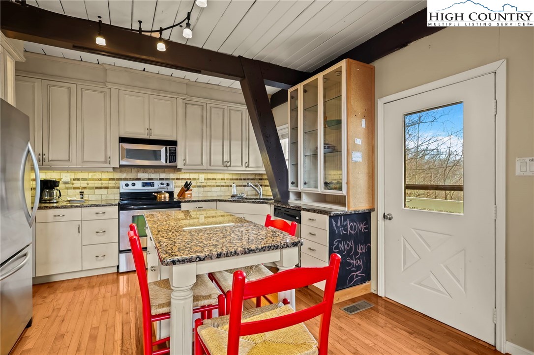 207 Pinnacle Ridge Road Beech Mountain, NC 28604 - Photo 14 of 48 a kitchen with granite countertop a stove a sink and a refrigerator
