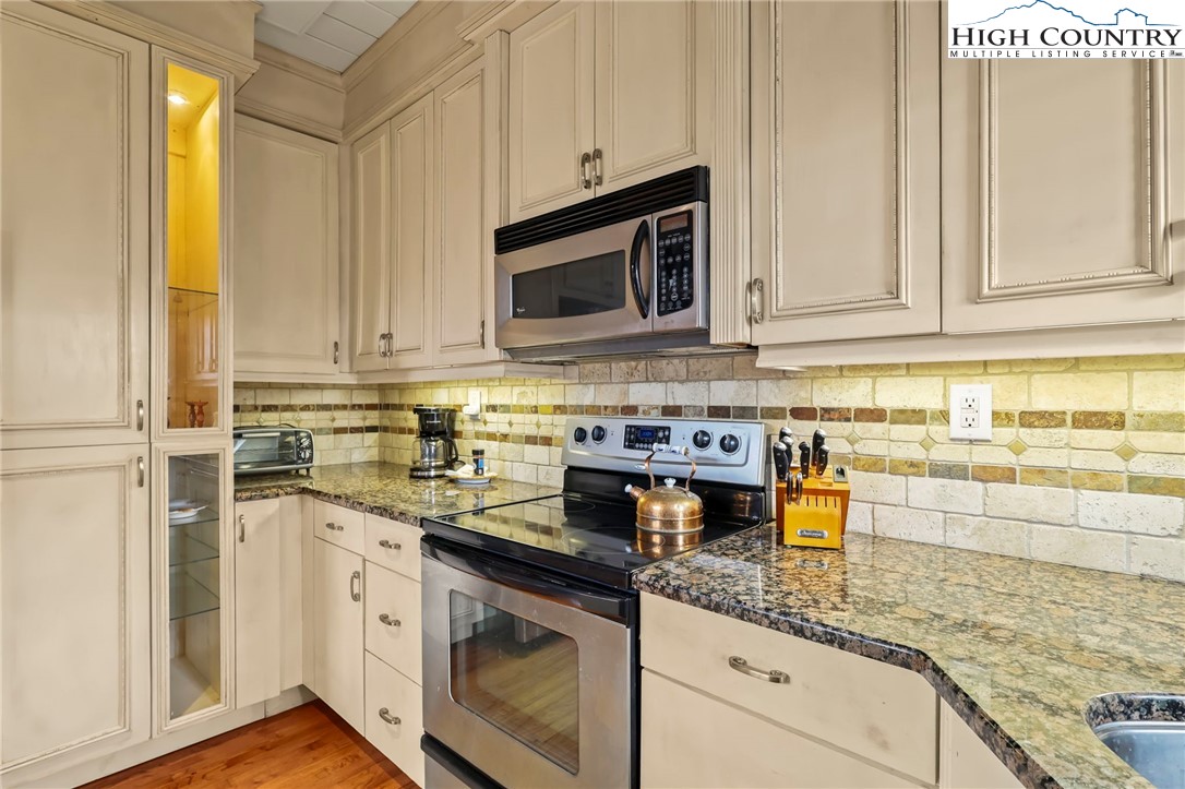 207 Pinnacle Ridge Road Beech Mountain, NC 28604 - Photo 15 of 48 a kitchen with stainless steel appliances granite countertop a sink a stove and a microwave