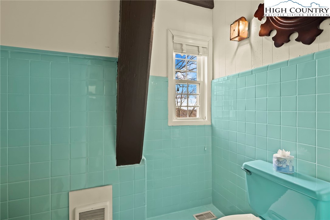 207 Pinnacle Ridge Road Beech Mountain, NC 28604 - Photo 30 of 48 a bathroom with a toilet and a shower curtain