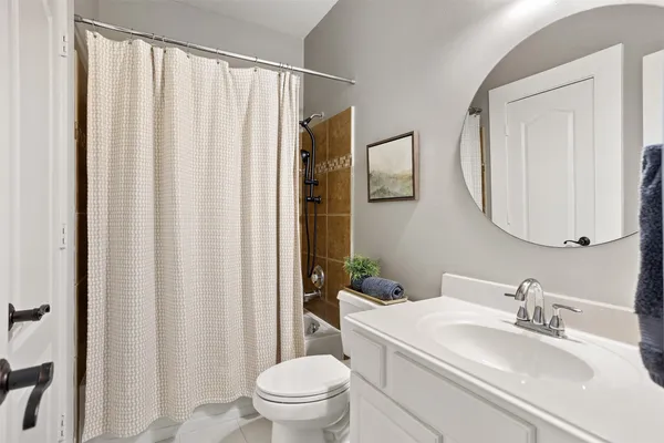 a bathroom with a granite countertop sink a mirror and a bathtub