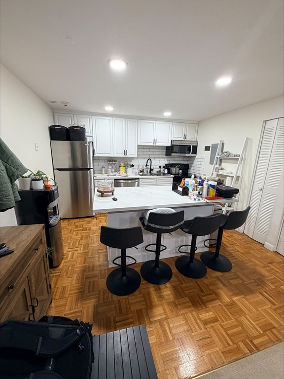 a kitchen with a sink and chairs