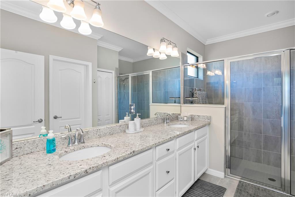 19828 The Pl Boulevard Estero, FL 33928 - Photo 14 of 37 a bathroom with a granite countertop double vanity and a mirror