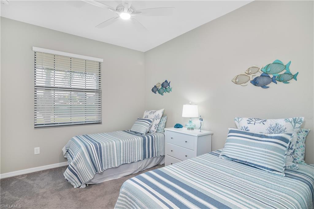 19828 The Pl Boulevard Estero, FL 33928 - Photo 17 of 37 a bedroom with two beds and a chandelier